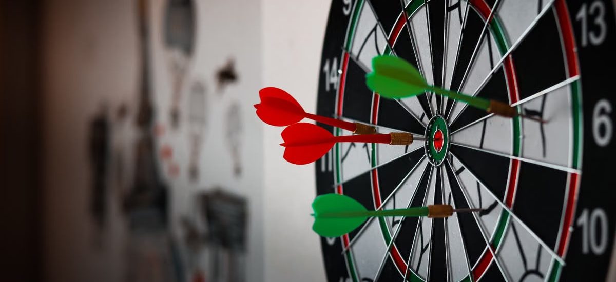 Close-up of a dartboard with multiple darts hitting the target, emphasizing precision and focus.