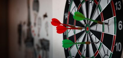Close-up of a dartboard with multiple darts hitting the target, emphasizing precision and focus.